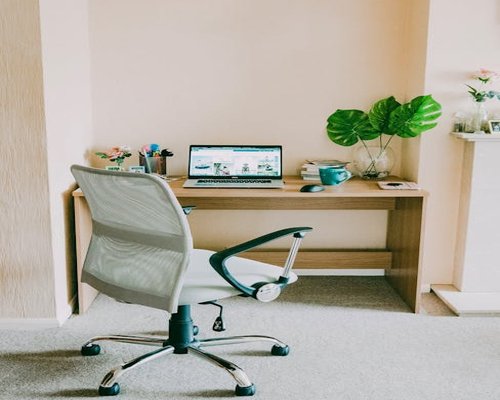 Balanced workspace setup with ergonomic chair and laptop screen